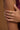Close-up of a hand wearing gold rings with a blurred background