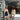 Two women posing in front of a store with floral decorations.