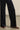 Navy blue pants worn with brown shoes on a neutral background