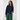 Woman wearing a navy bomber jacket with green accents on a white background