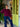 Woman standing in front of a green door with plants and furniture in the background
