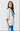 Woman wearing a white oversized t-shirt with a blue graphic design on a plain background