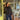 Woman standing in a store doorway wearing a black jacket and blue jeans.