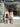 Two women in matching outfits standing in front of a store window with floral decorations.