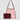 Pink mesh handbag with burgundy leather accents on a light gray background