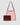 Pink mesh handbag with burgundy leather accents on a light gray background