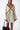 Woman wearing a cream dress with brown accents on a white background
