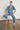 Ascend Pant Mid Wash Denim lifestyle shot featuring a relaxed fit, cotton-lyocell blend, and ankle-length leisurewear style.