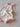 Bloom Pointelle Tie Romper soft cream pointelle knit baby bodysuit featuring adjustable tie shoulders and Cosmos embroidery shown in an angled view.