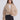 Woman wearing a beige fluffy jacket on a white background