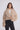 Woman wearing a beige fluffy jacket on a white background
