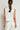 Back view of the Charge Vest in elm white, emphasizing the sleeveless design, cropped boxy shape, and clean tailored back finish.