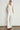 Full length view of a model wearing the Charge Vest in elm fresh white paired with matching trousers, showcasing a cropped boxy silhouette and double-breasted design.