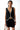 Woman wearing a black sleeveless dress with a white trim on a white background
