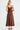Back view of the chocolate brown linen slip dress with thin adjustable straps and a graceful drape.