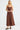 Chocolate brown bias-cut linen slip dress with thin straps and a midi-to-maxi length.