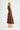 Side view of the Dickens linen dress in chocolate highlighting its fluid shape.