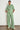 Full length view of a model wearing the Driftline Pant in Apple green paired with a matching top, showcasing a high-rise straight-leg fit.