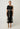 Elodie One Shoulder Embroidery Dress Black front view featuring a fitted bodice and straight midi skirt in a breathable linen-viscose blend.