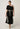 Elodie One Shoulder Embroidery Dress Black model view showcasing the versatile fit and elegant midi length.