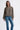 Woman wearing a plaid shirt and blue jeans on a white background