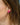 Flora flower stud earring featuring a three-petalled enamel flower design in hot pink worn by a model.