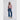 Woman wearing a pink sweater and blue jeans on a white background