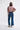 Person wearing a pink sweater and blue jeans on a white background