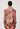 Woman wearing a patterned dress with long sleeves on a plain background