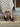 Front view of the Gala Wedge in black leather showcasing its leather upper, open toe, and delicate ankle strap styling.