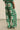 Zoe Kratzmann Green and white patterned pants worn by a person on a beige background
