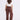 Woman wearing brown wide-leg pants and a white top on a white background