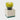Green glass tulip-shaped verbena and lemongrass scented candle lit, highlighting its warm glow and earthy charm.