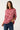 Woman wearing a red and white striped sweater with blue jeans on a plain background