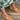 Side angled view of the Inclination Wedge in cinnamon raffia showcasing its 8.5cm wedge heel, squared toe, and knotted raffia upper.