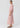 Innes Tuck Top in Pink shown from the side, featuring a stunning viscose satin fabric, oversized body fit, round neckline, and elbow-length sleeves with elasticised cuff detail.