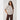 Woman wearing a striped shirt and brown pants on a white background