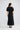 Jocelyn Dress in Black shown from the back, featuring an invisible zipper and a fluted hem panel.