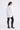Woman wearing a white shirt, black leggings, and gray knee-high boots on a white background