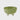 Green ceramic bowl with white feet on a light gray background