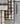 Larder Check Tea Towel featuring a classic check pattern hanging in a kitchen setting.