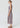 Lattice Gathered Dress in Pink Check shown from the side, highlighting its sleek slim-fitting waist, side seam pockets, and flared midi length satin skirt.