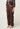 Oxblood leather pants worn with a patterned top on a white background