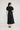 Lucienne Dress Black featuring a regular fit and babydoll styling viewed from the back.