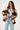 Woman wearing a plaid jacket with a white background