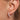 Model wearing the Lyla gold huggie earrings on the earlobe.