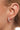 Model wearing the Lyla gold huggie earrings on the earlobe.