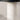Close-up texture view of the luminous white travertine cylindrical base.