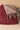 Close-up texture view of the burgundy/grey reversible merino wool throw showing the folded corner and tassels.