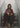 Lifestyle portrait of a woman sitting on stairs wrapped in burgundy/grey reversible merino wool throw.
